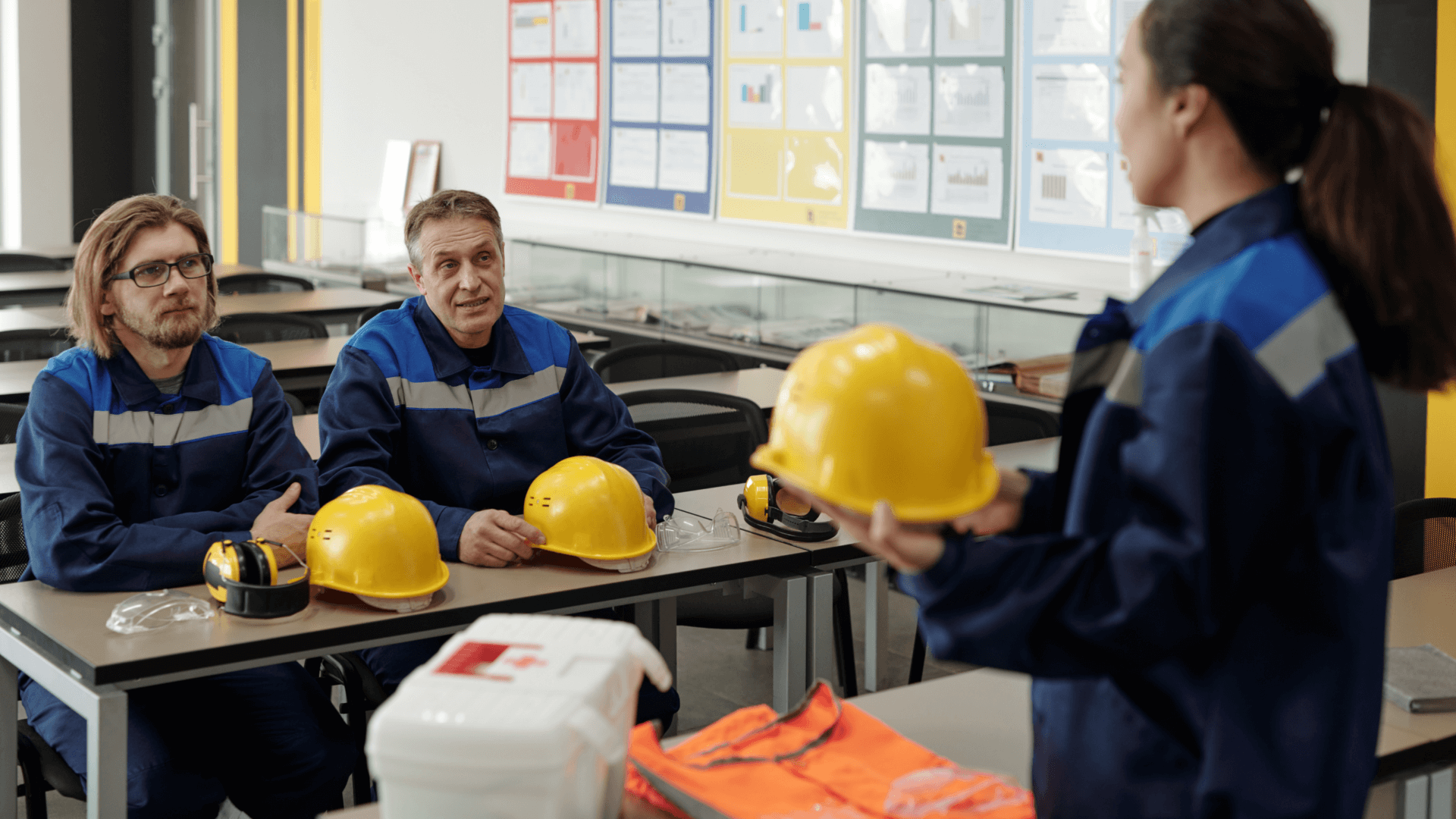 Instrutor de segurança do trabalho realizando treinamento prático com trabalhadores sobre o uso correto de EPIs.