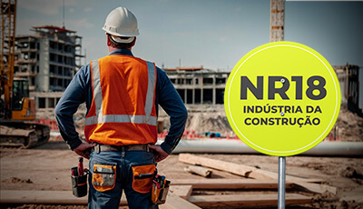 Trabalhadores usando EPIs em um canteiro de obras conforme a NR-18.