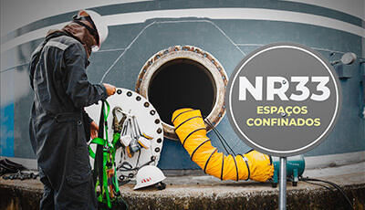 Trabalhador utilizando EPIs adequados enquanto realiza atividades em um espaço confinado, seguindo as diretrizes da NR-33.