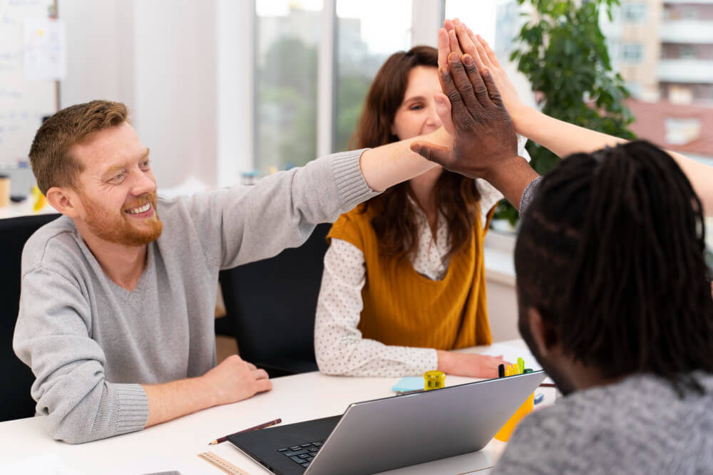 Equipe de colaboradores reunida em um ambiente corporativo, comemorando resultados e demonstrando engajamento.