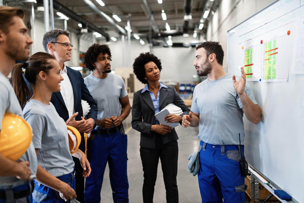 Colaboradores participando de um treinamento de segurança no trabalho, com um instrutor apresentando normas e diretrizes.